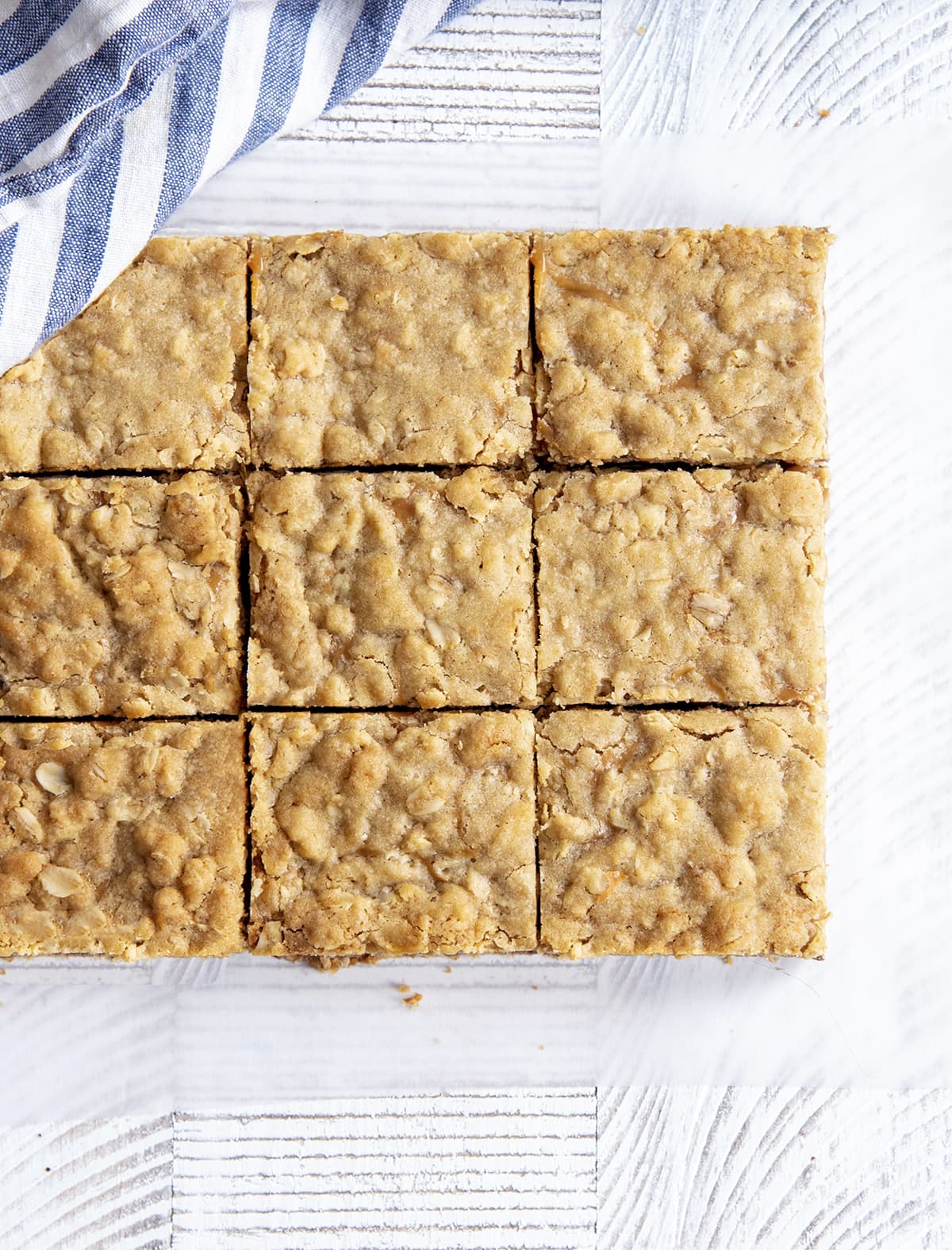 An overhead shot of sliced caramel chocolate oatmeal bars still together in a block.