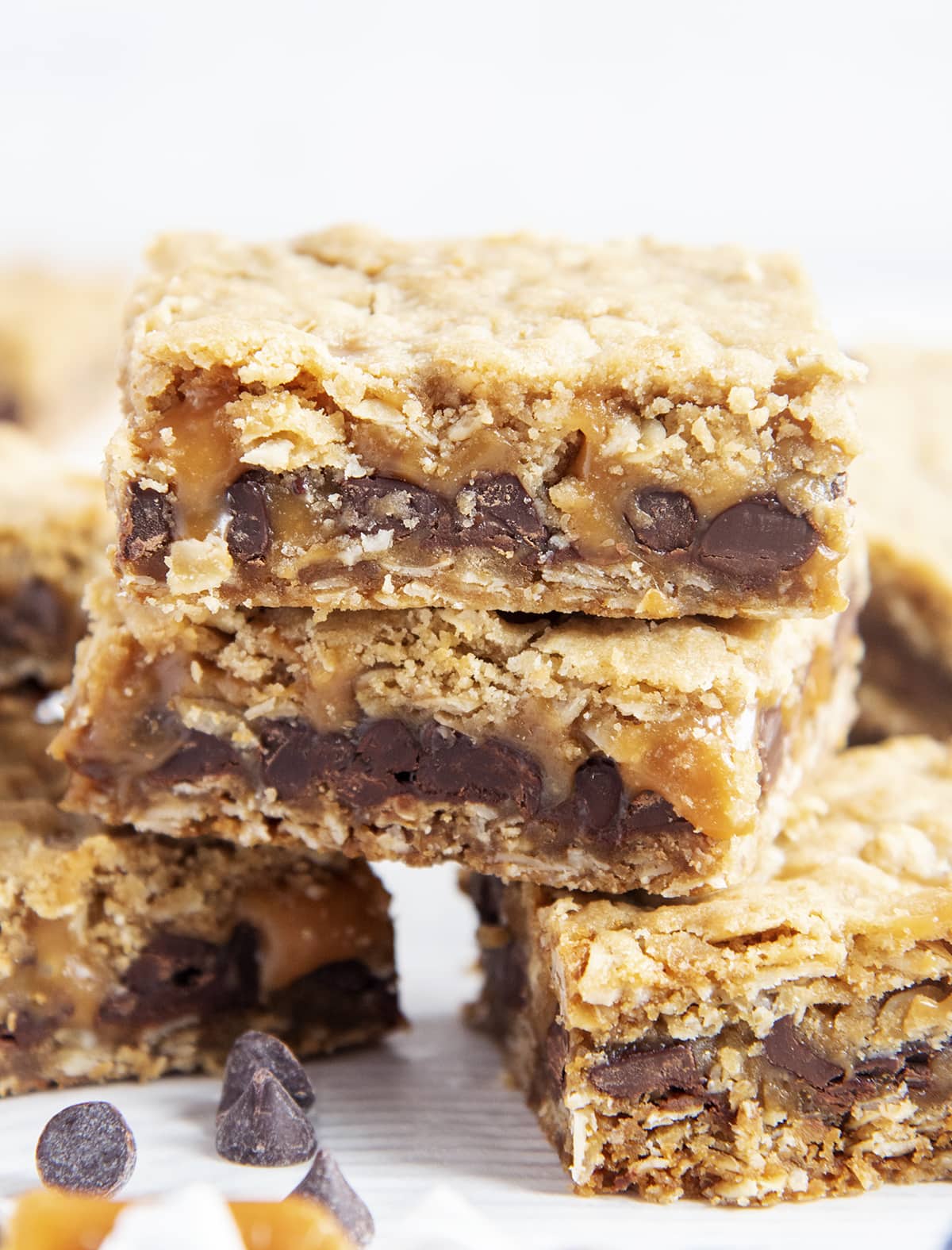 A close up of a pile of carmelitas bars, with layers of oatmeal on each side and chocolate and caramel in the middle.