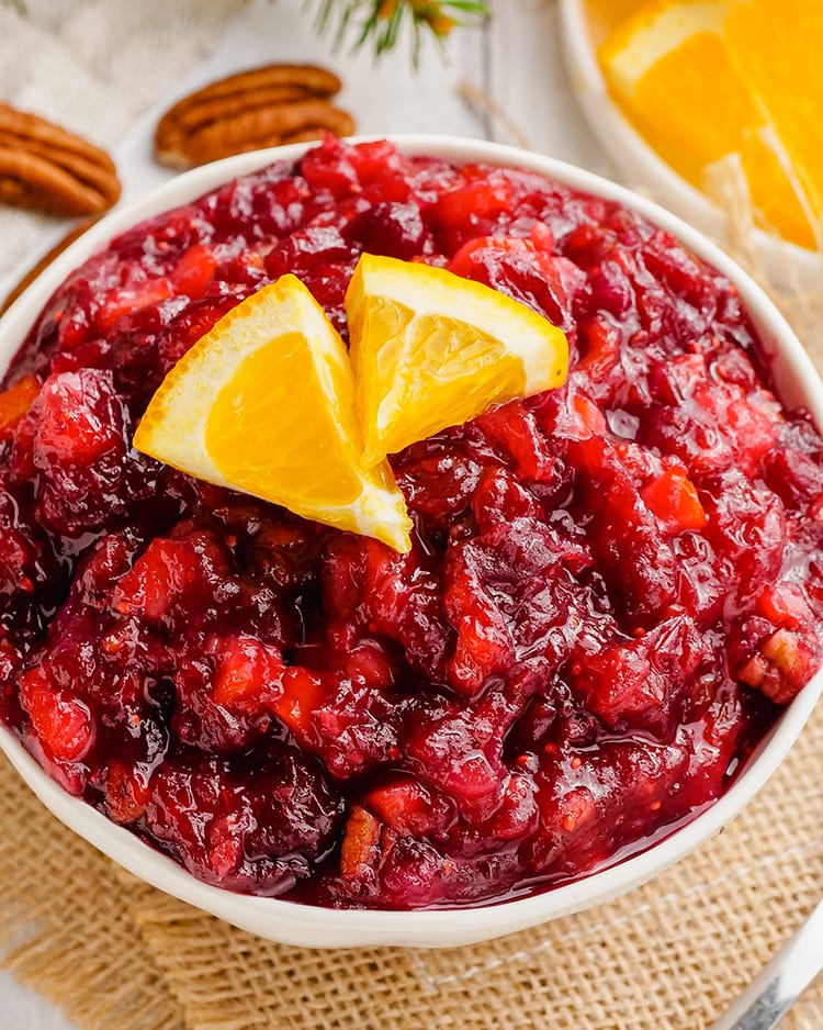 A close up shot of a white bowl full of cranberry orange sauce.