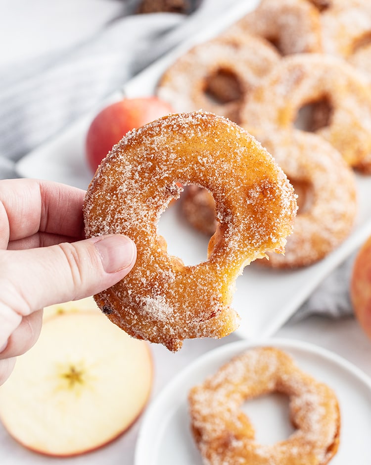 A bite out of a homemade apple donut.