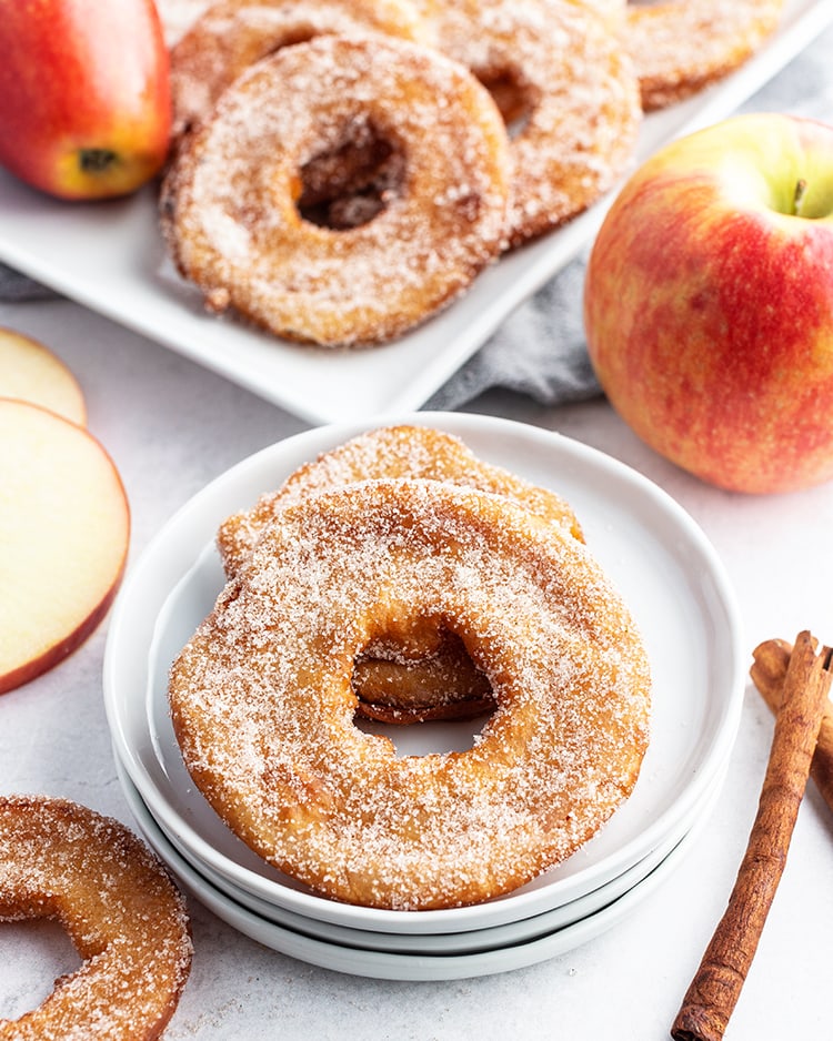 Two deep fried apple rings on a plate.