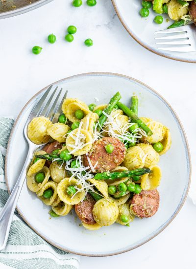 An overhead photo of a plate or asparagus, chicken, and orecchiette pasta.