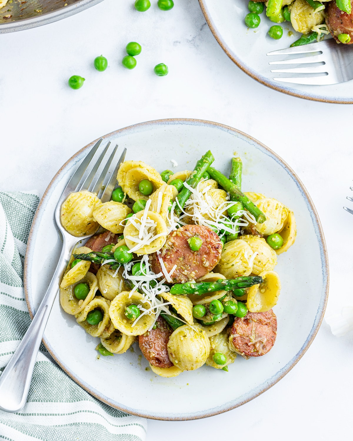 An overhead photo of a plate or asparagus, chicken, and orecchiette pasta.