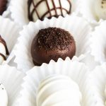 A close up image of a chocolate covered oreo ball topped with Oreo crumbs.