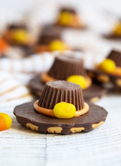 A Fudge Stripe cookie decorated to look like a Pilgrim Hat with a Peanut butter cup on top.