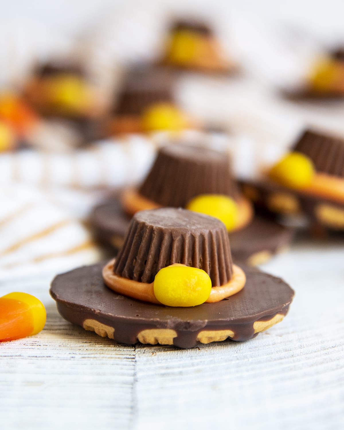 A Fudge Stripe cookie decorated to look like a Pilgrim Hat with a Peanut butter cup on top.