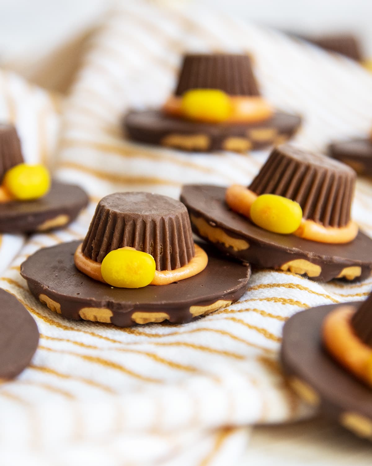 Two cookies made to look like Pilgrim Hats with Miniature Reeses and a Candy corn buckle.