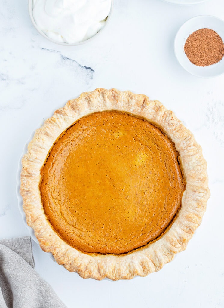 An above view of a pumpkin pie with a fluted crust.
