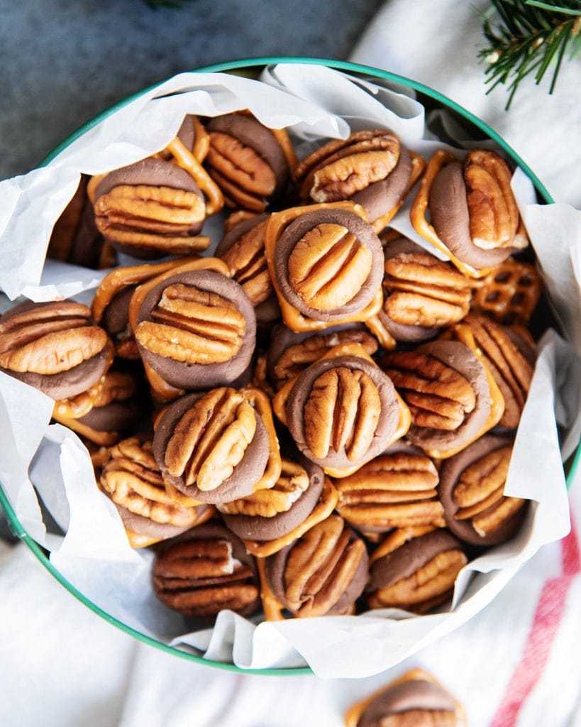 A metal tin full of a pile of rolo pretzel turtles.