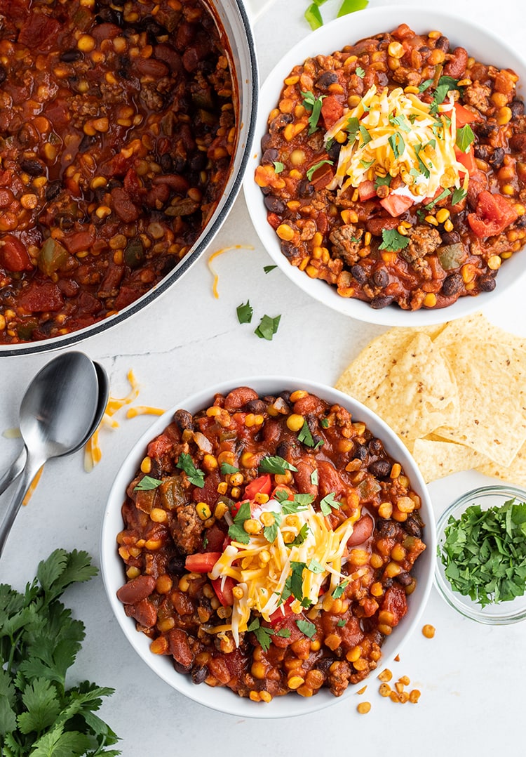 Two bowls of split pea tortilla soup topped with sour cream and cheese