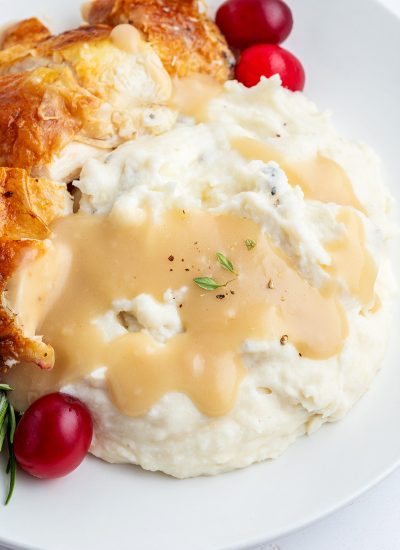 A close up of thanksgiving gravy on a pile of mashed potatoes.