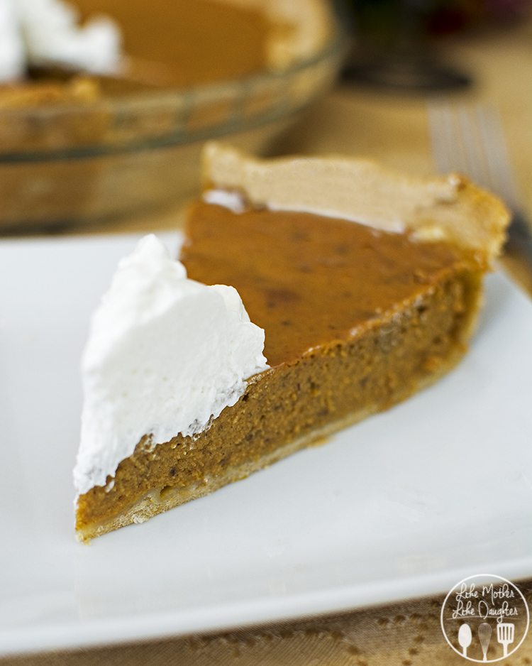 A slice of pumpkin pie topped with whipped cream on the end.