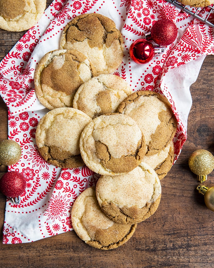 A pile of half snickerdoodle half ginger molasses cookies on a red and white cloth.