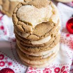 A stack of half ginger molasses, half snickerdoodle cookie swirled together. The top cookie has a bite taken out of it.