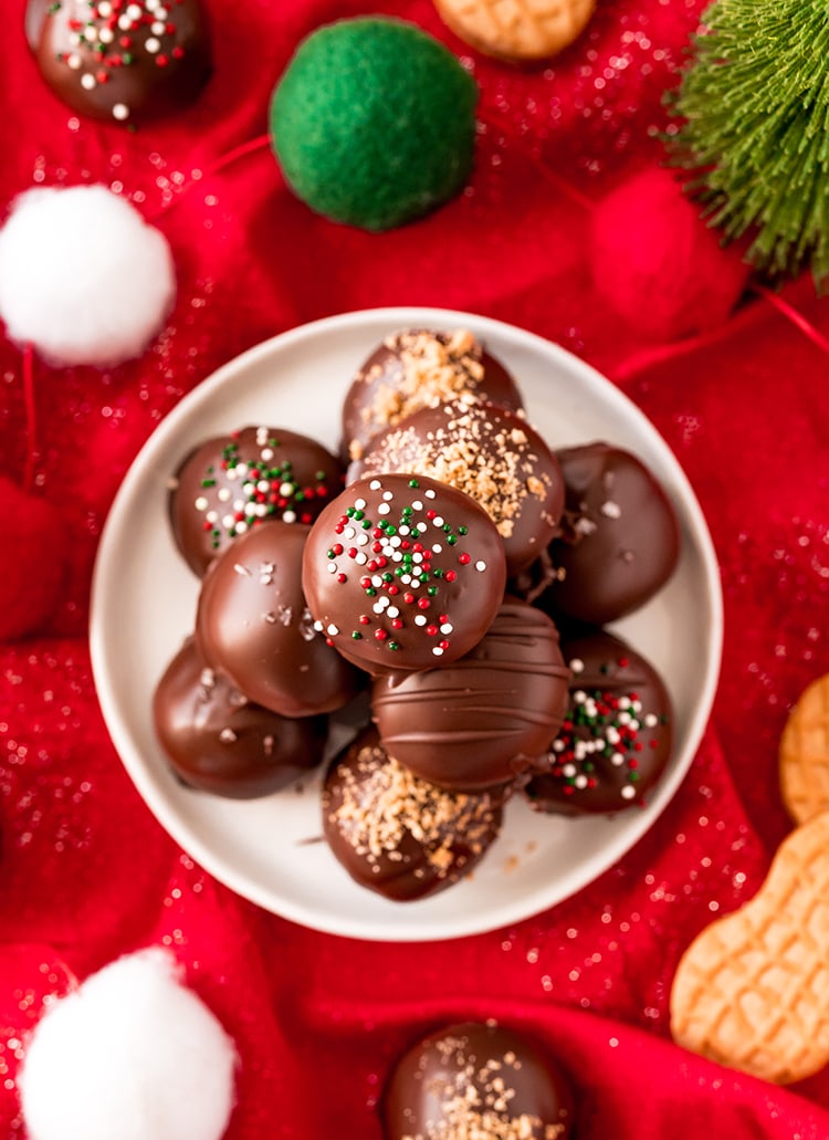 A stack of Nutter Butter Truffles dipped in chocolate, and sprinkled with sprinkles and nutter butter crumbs.
