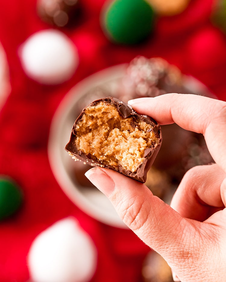 Fingers holding a nutter butter truffle bit in half, showing the truffle center.