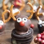 An oreo truffle decorated with candy eyes, a candy nose and pretzels to look like a reindeer.