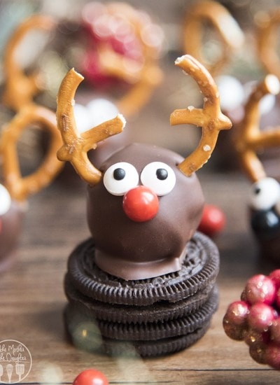 An oreo truffle decorated with candy eyes, a candy nose and pretzels to look like a reindeer.