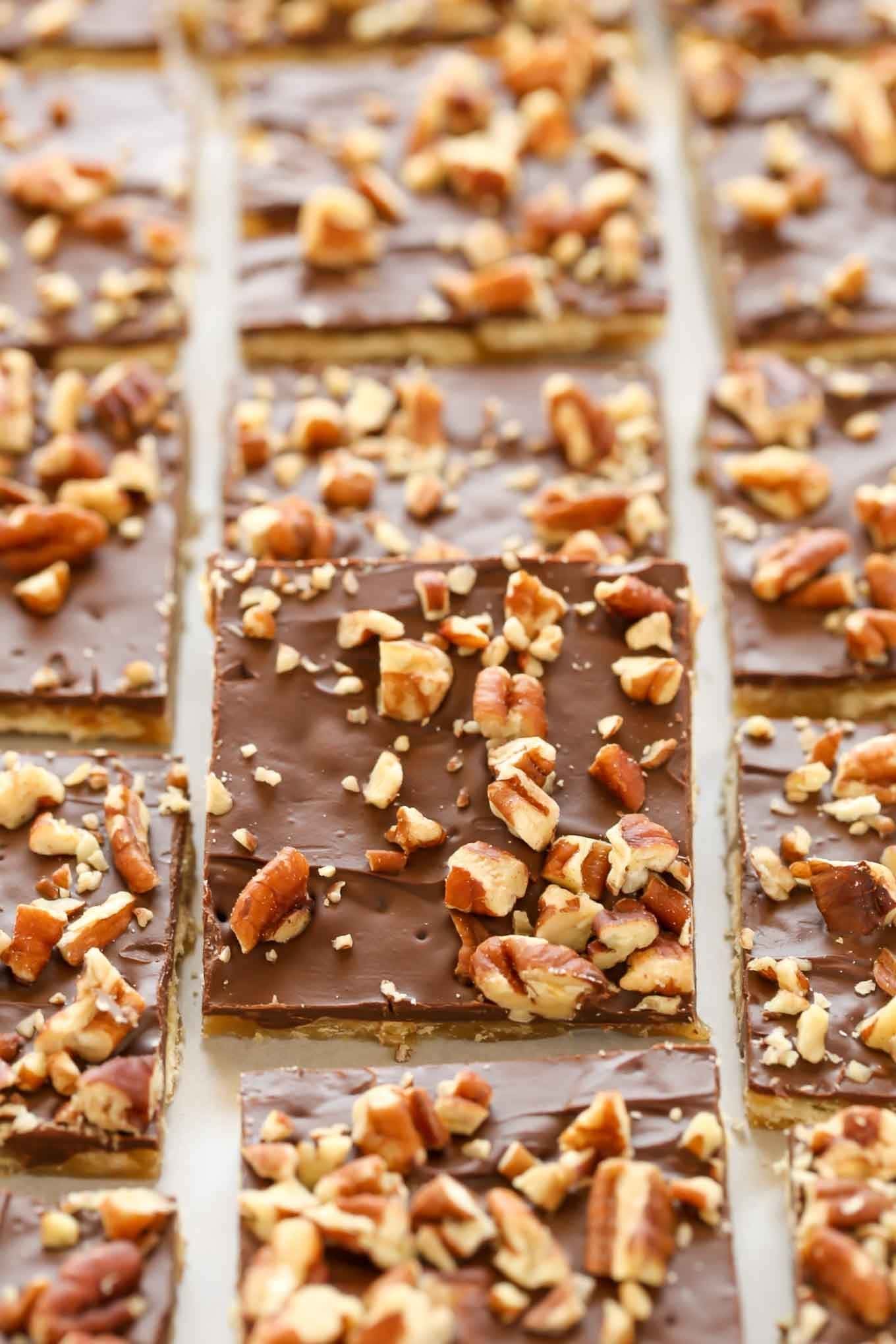 A tray of salting toffee cut into nice squares, showing the chocolate on top, and topped with chopped nuts.