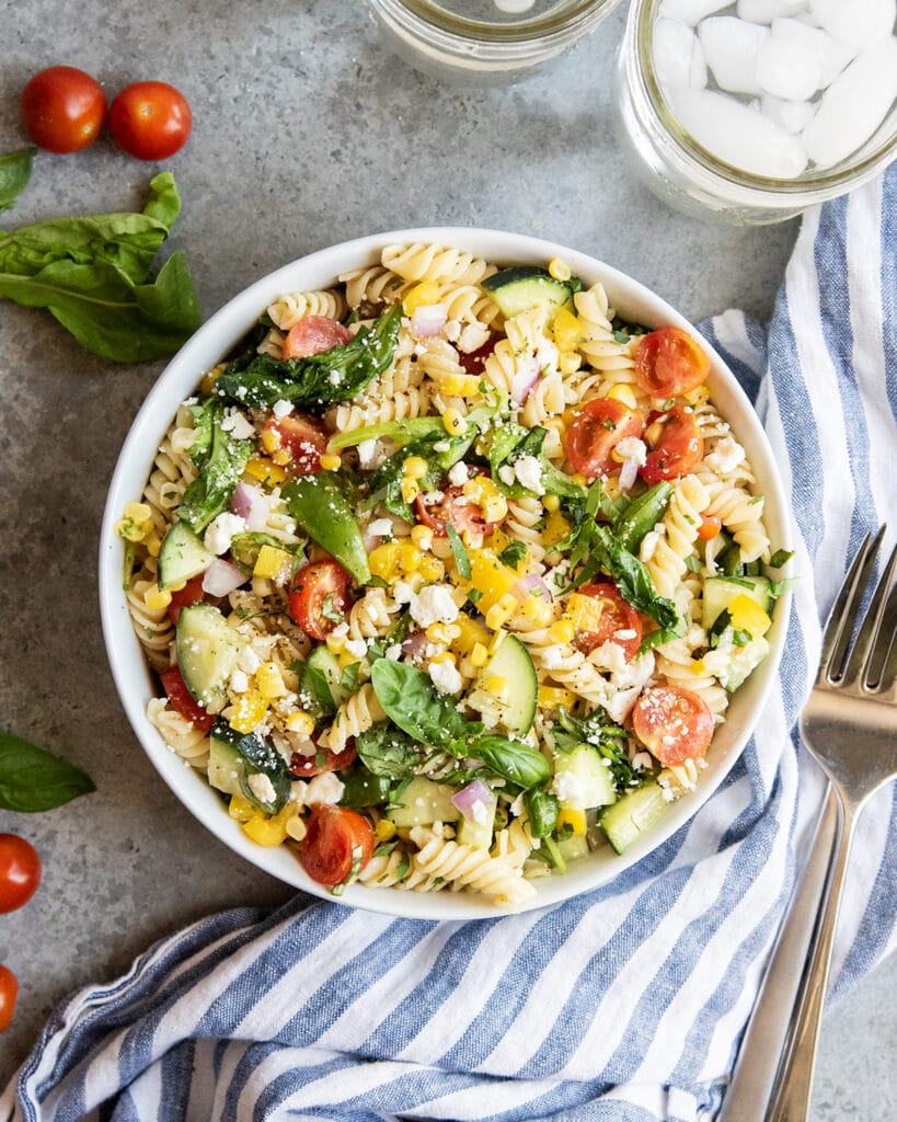 An above photo of a bowl of pasta salad loaded with veggies.