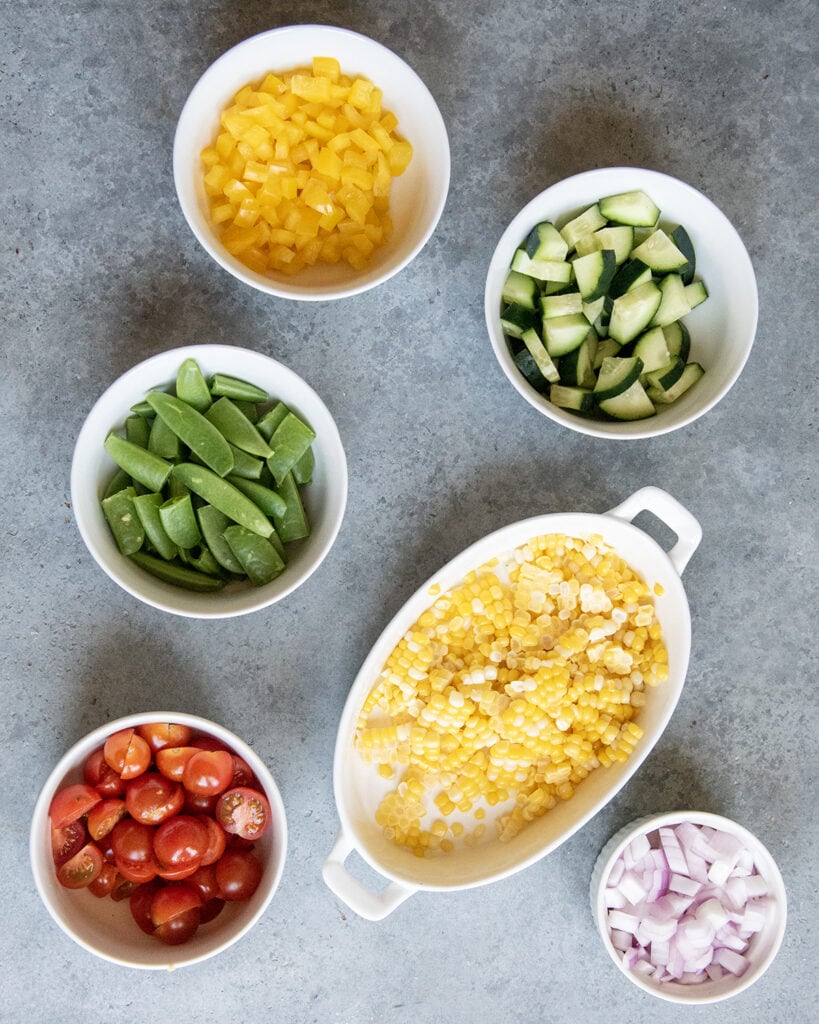 Small bowls of chopped up vegetables.