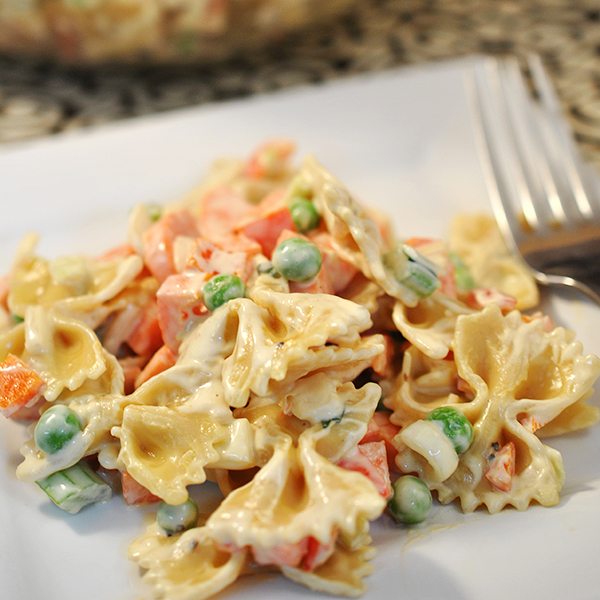 Close up of vegetable pasta salad on a white plate.