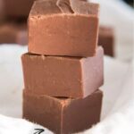 Three pieces of chocolate fudge in a stack with a text block over the top saying "Microwave Fudge".