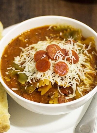 Angled view of one pot hormel pepperoni pizza soup in a white bowl.