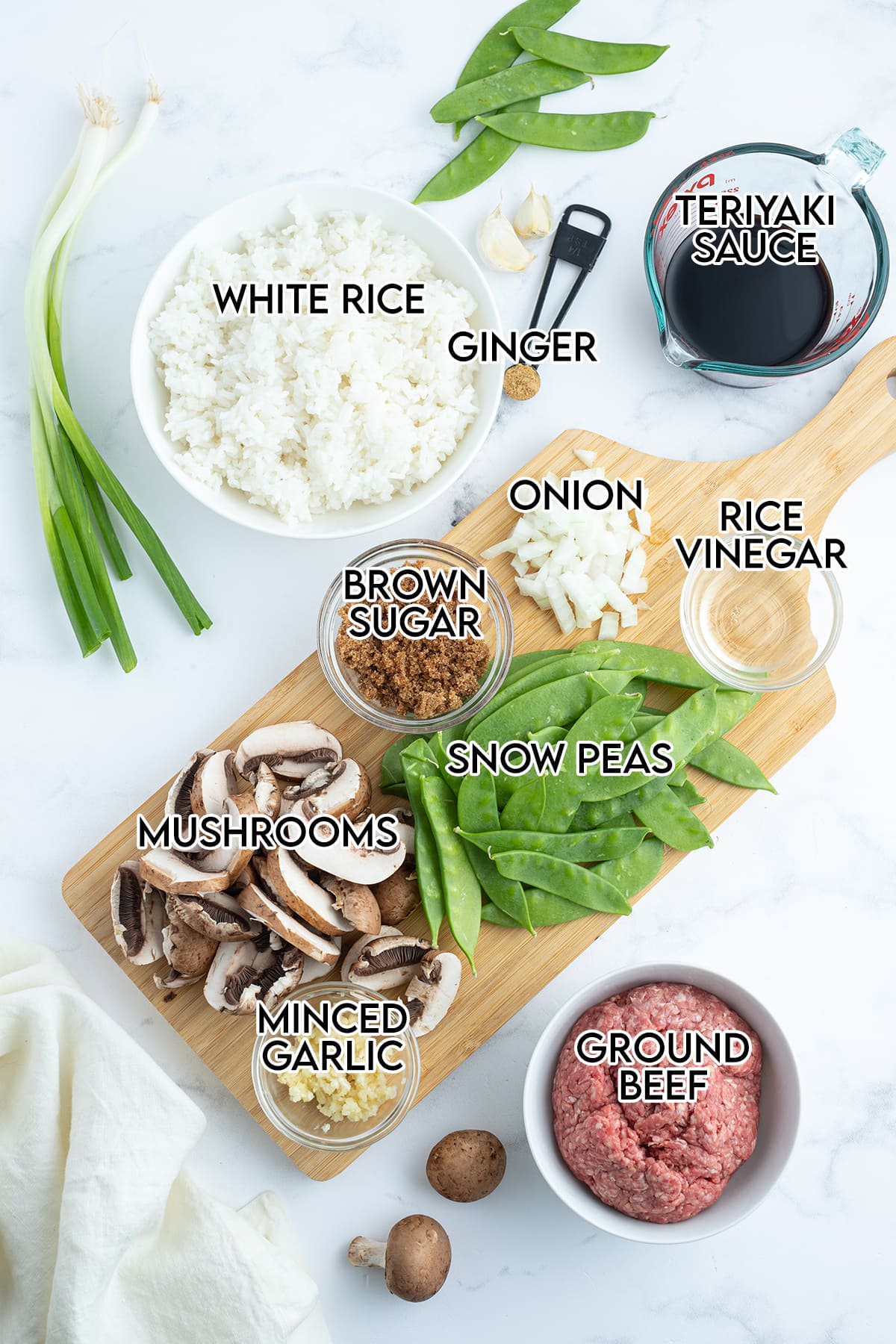 An overhead photo of the ingredients needed to make Beef with Snow Peas with text overlay over them.