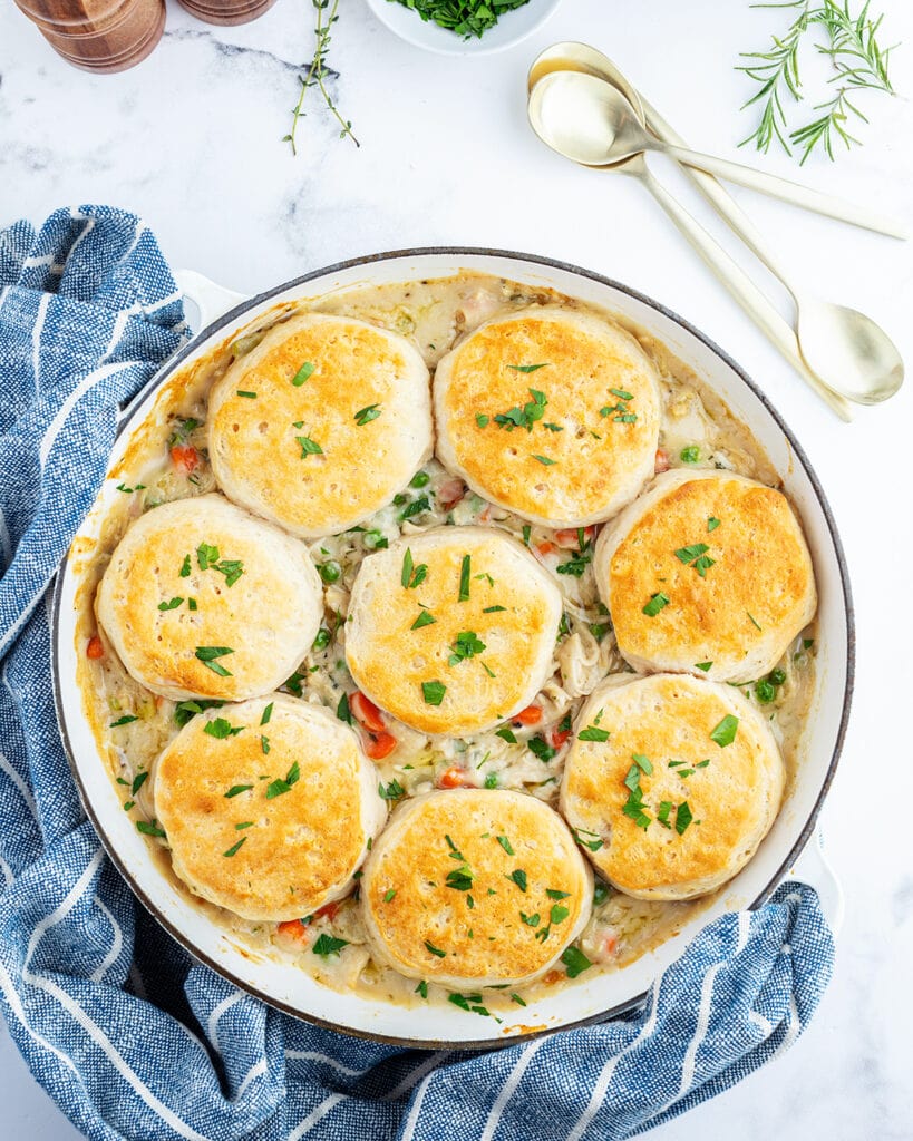 An overhead photo of a pan of biscuit chicken pot pie topped with fresh parsley.