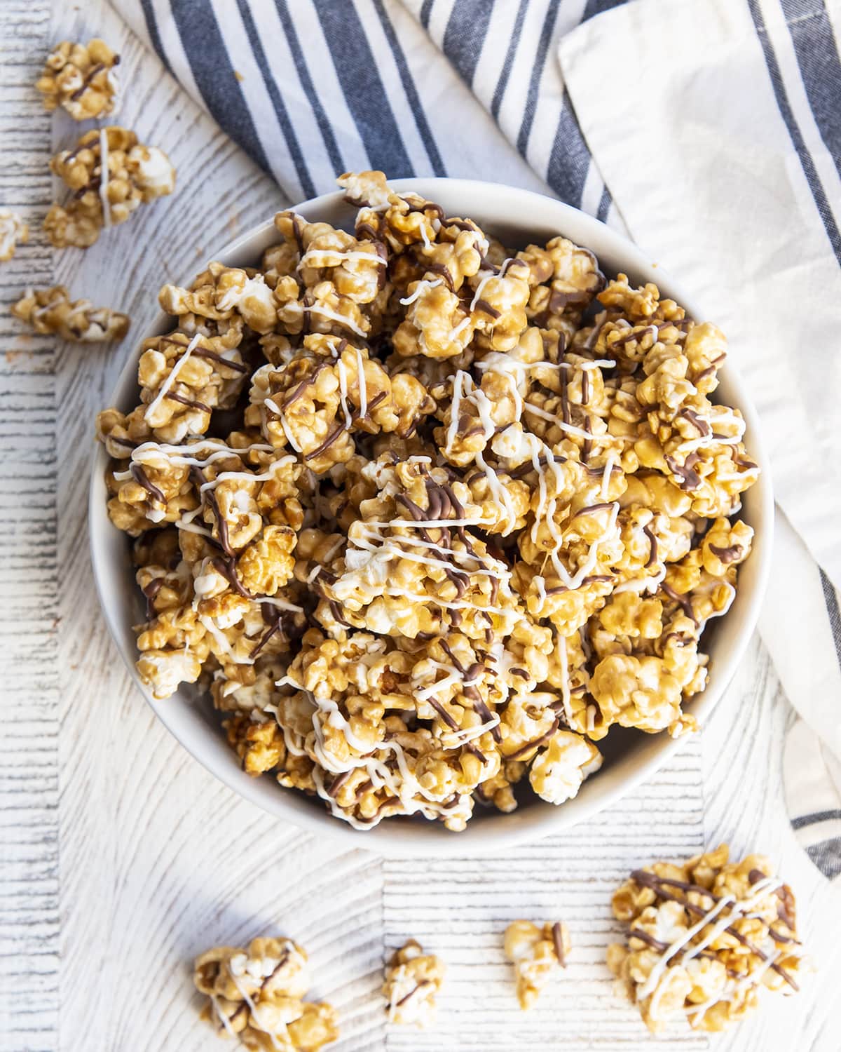 An overhead photo of a bowl of Caramel Zebra popcorn, drizzled with chocolate and white chocolate.
