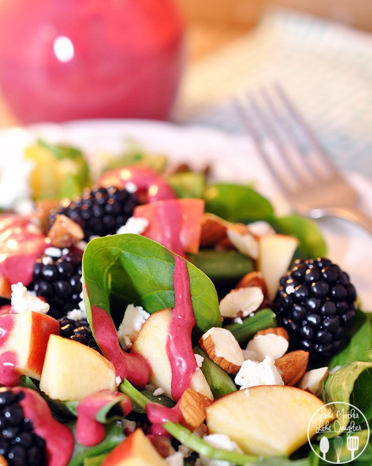 Angled view of blackberry salad on a white plate.