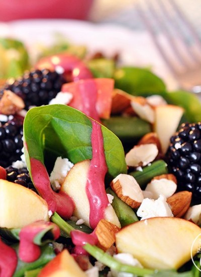 Angled view of blackberry salad on a white plate.