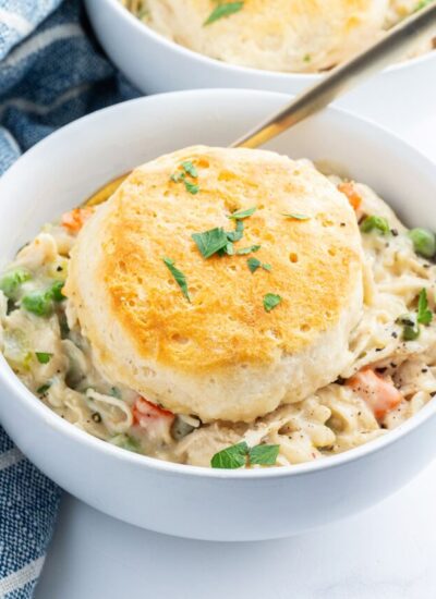 A bowl of chicken pot pie with a biscuit on top.