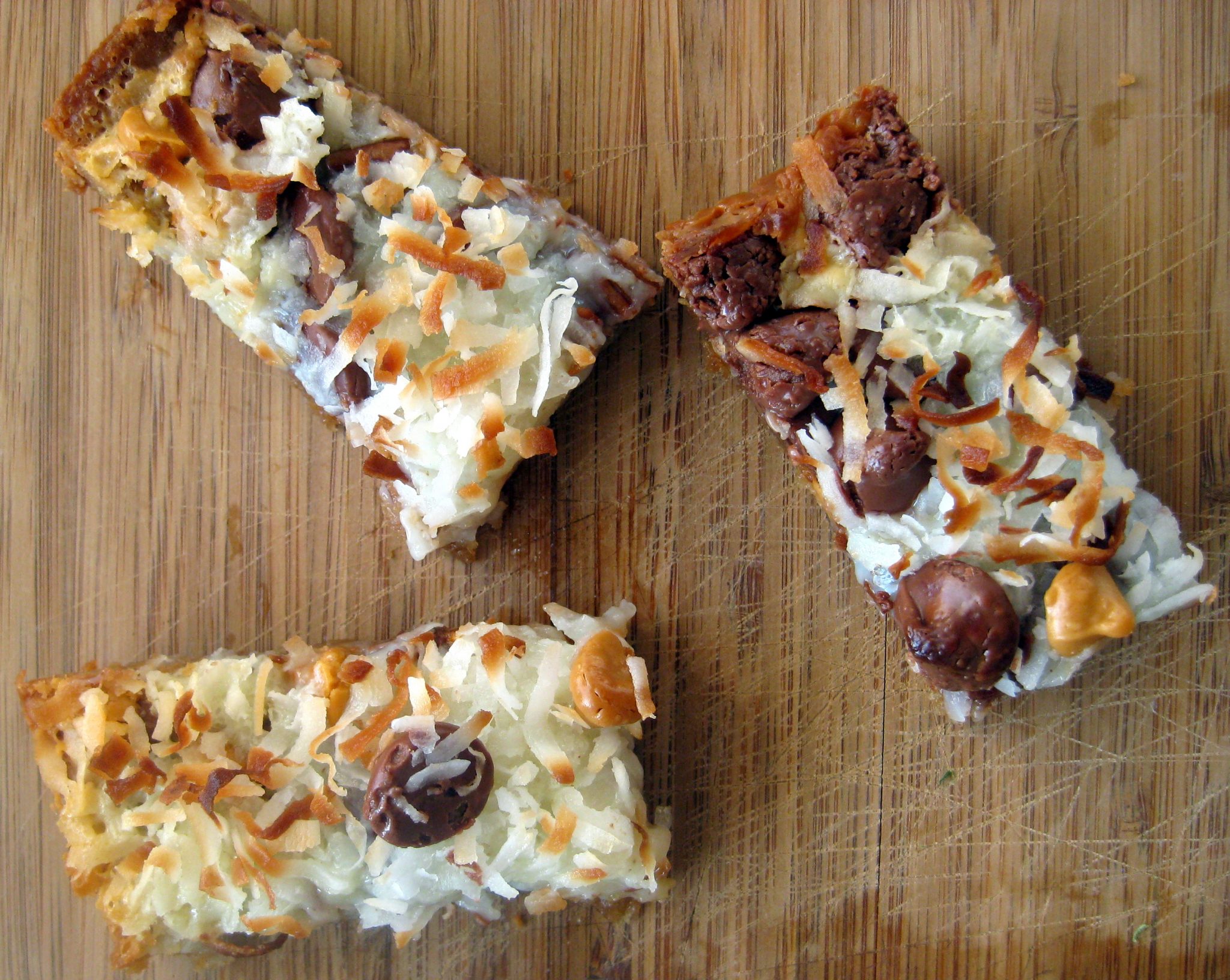 Slices of magic bars on a wood cutting board.