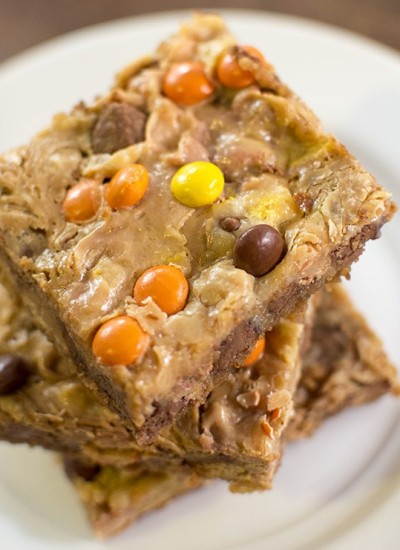 Top view of a stack of reeses pieces magic bars on a white plate.