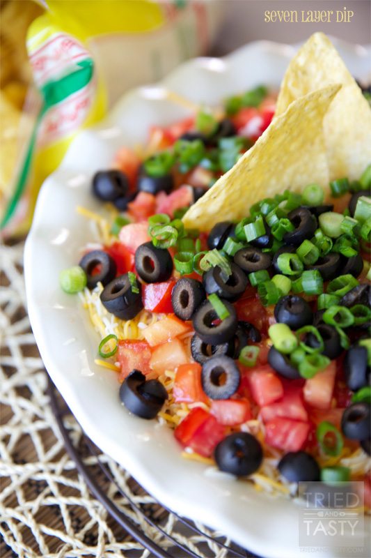 Close up view of seven layer dip on a white plate.