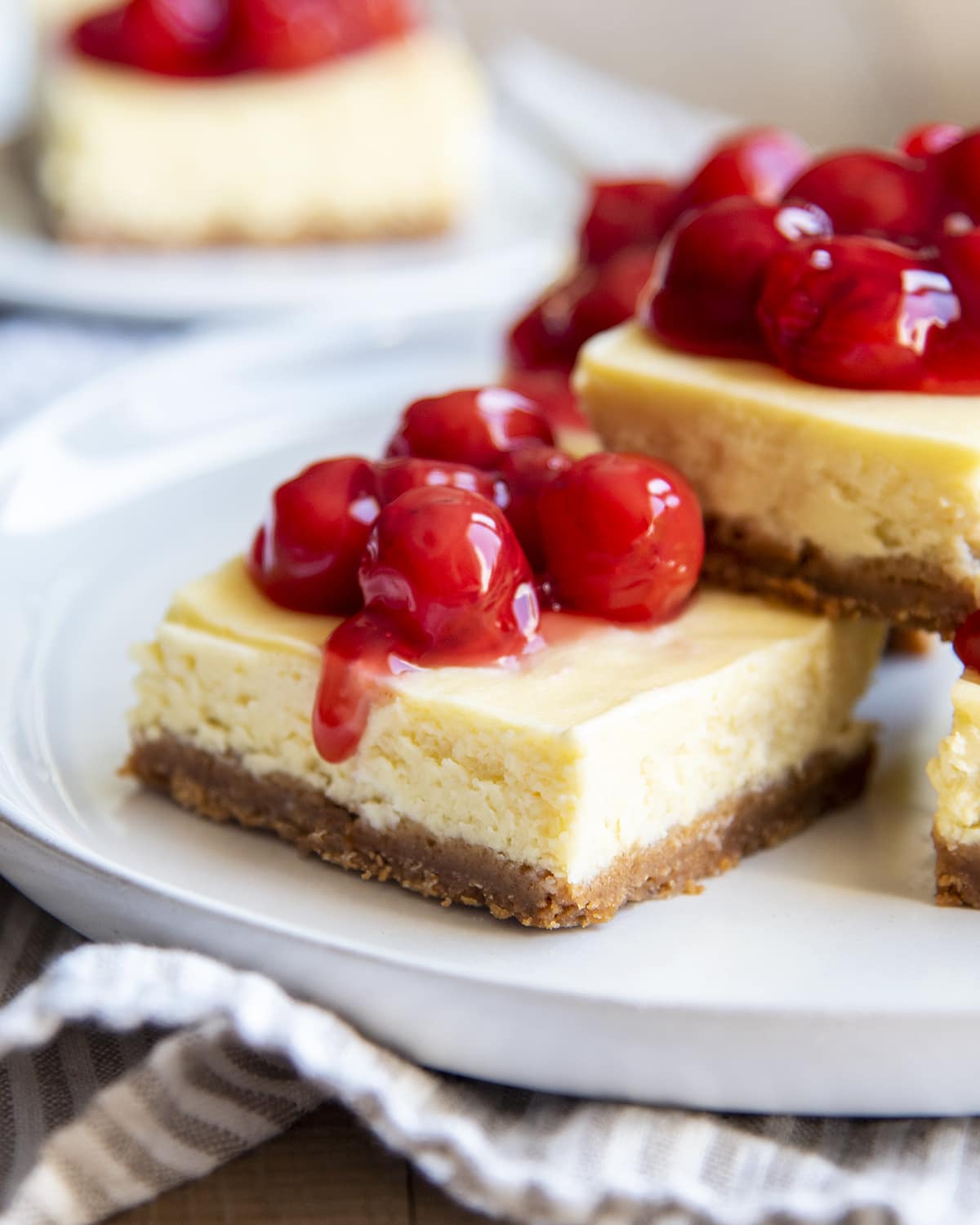 A pileof cherry cheesecake bars on a plate.