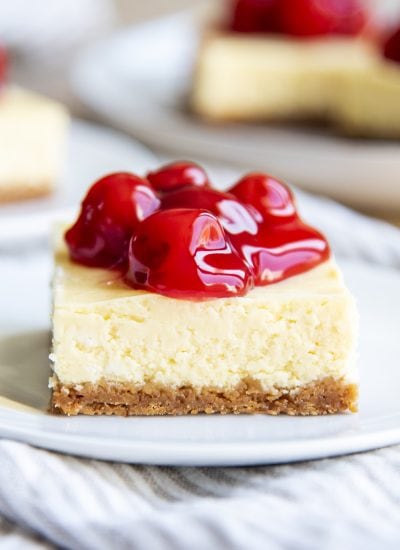 A cherry cheesecake bar on a white plate.