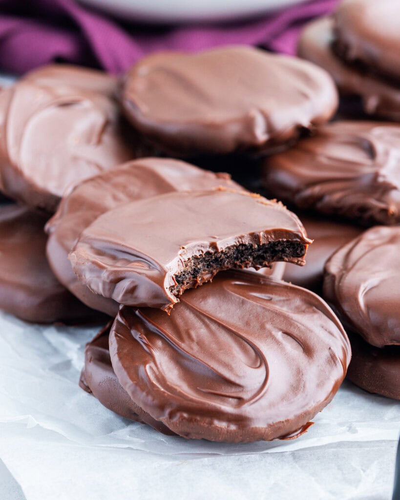 Homemade thin mint cookies in a pile, and one has a bite out of it.