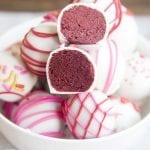 A close-up image of red velvet cake balls cut in half showing their red core.