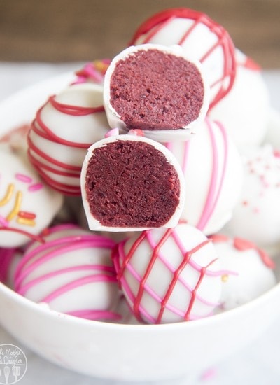 A close-up image of red velvet cake balls cut in half showing their red core.