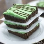 Angled view of chocolate mint sugar cookie bars stacked on a white plate.