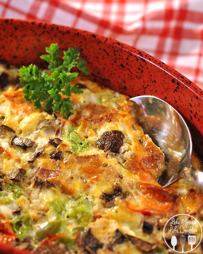 Close up view of baked omelet in a red casserole dish.