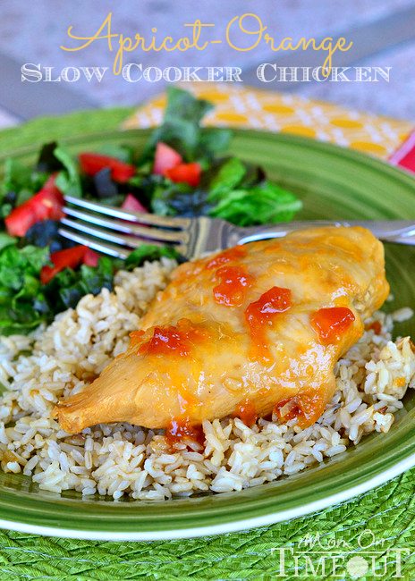 Close up of orange apricot slow cooker chicken on a green plate.
