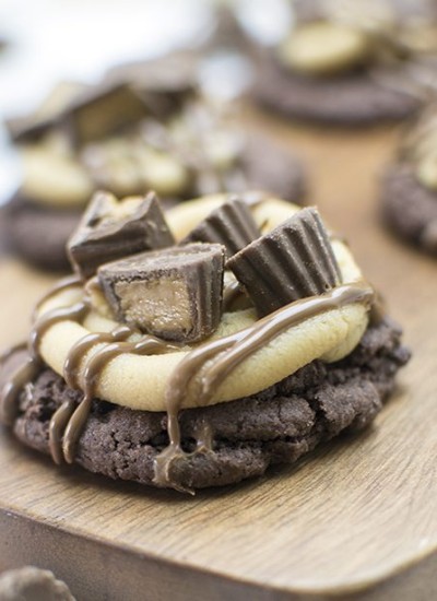 Front view of peanut butter cup cookies on a wood board.