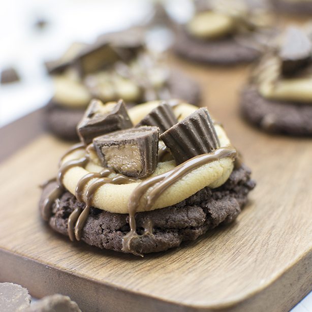 Front view of peanut butter cup cookies on a wood board.