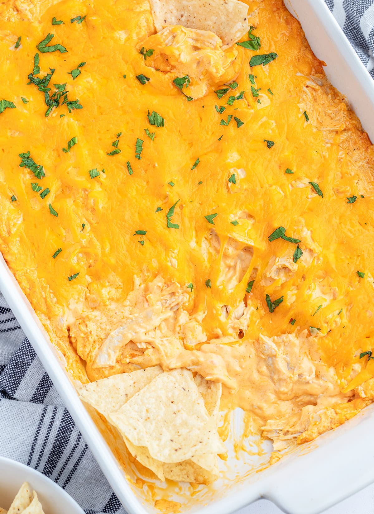 An above view of a pan of buffalo chicken dip with tortilla chips in it.