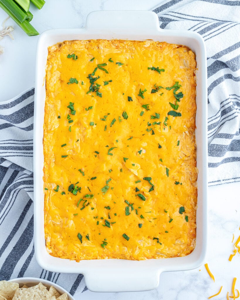 An above view of a pan of buffalo chicken dip topped with parsley.