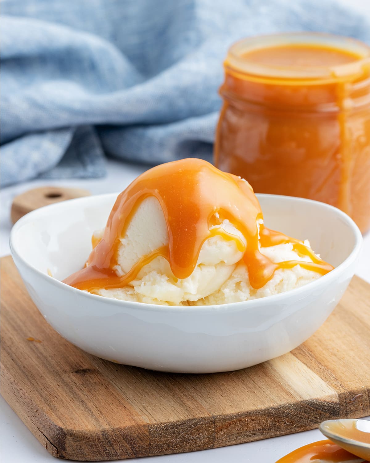 A bowl of vanilla ice cream topped with salted caramel sauce.